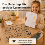 Kind zeigt stolz ein Lernergebnis neben der Affirmationen-Schreibtischunterlage aus Kork für positive Lernmomente