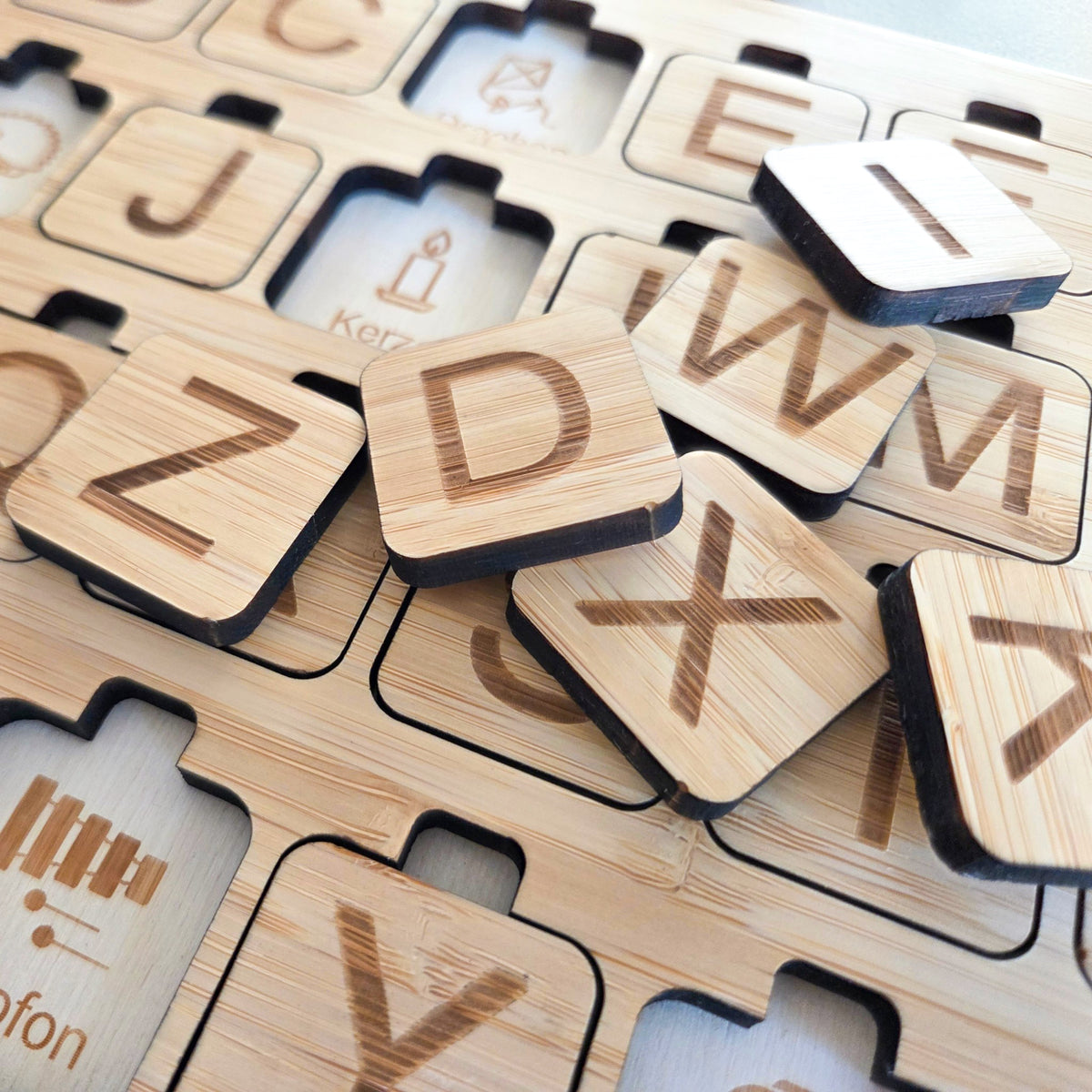 Detailansicht des Alphabet Puzzles aus Bambus und Birkenholz mit gravierten Buchstaben, Bildern und Begriffen